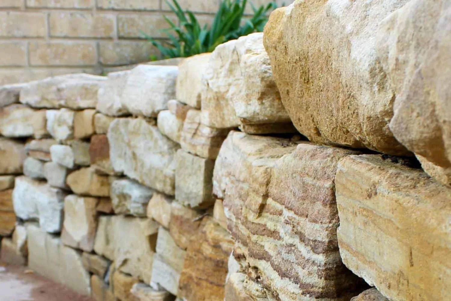 Tiered sandstone retaining wall with pebble garden bed